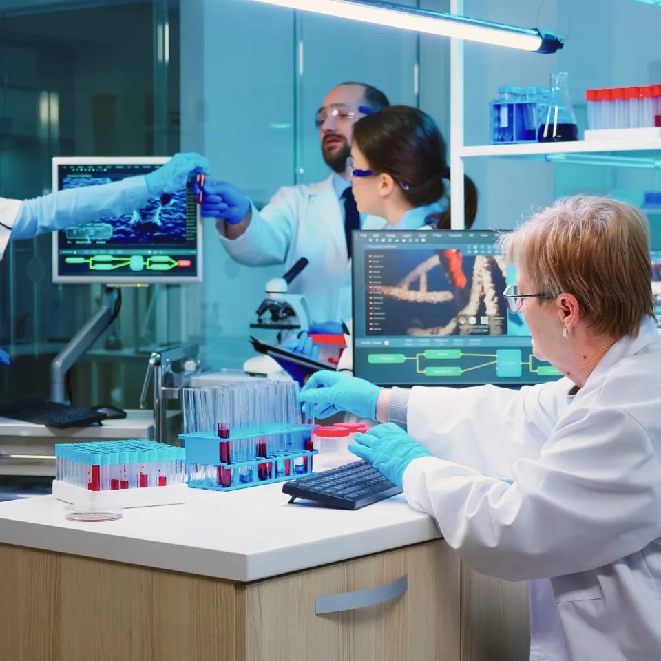 nurse-holding-tablet-computer-with-scientific-informations-while-chemist-using-microscope-with-chemical-test-tube-near